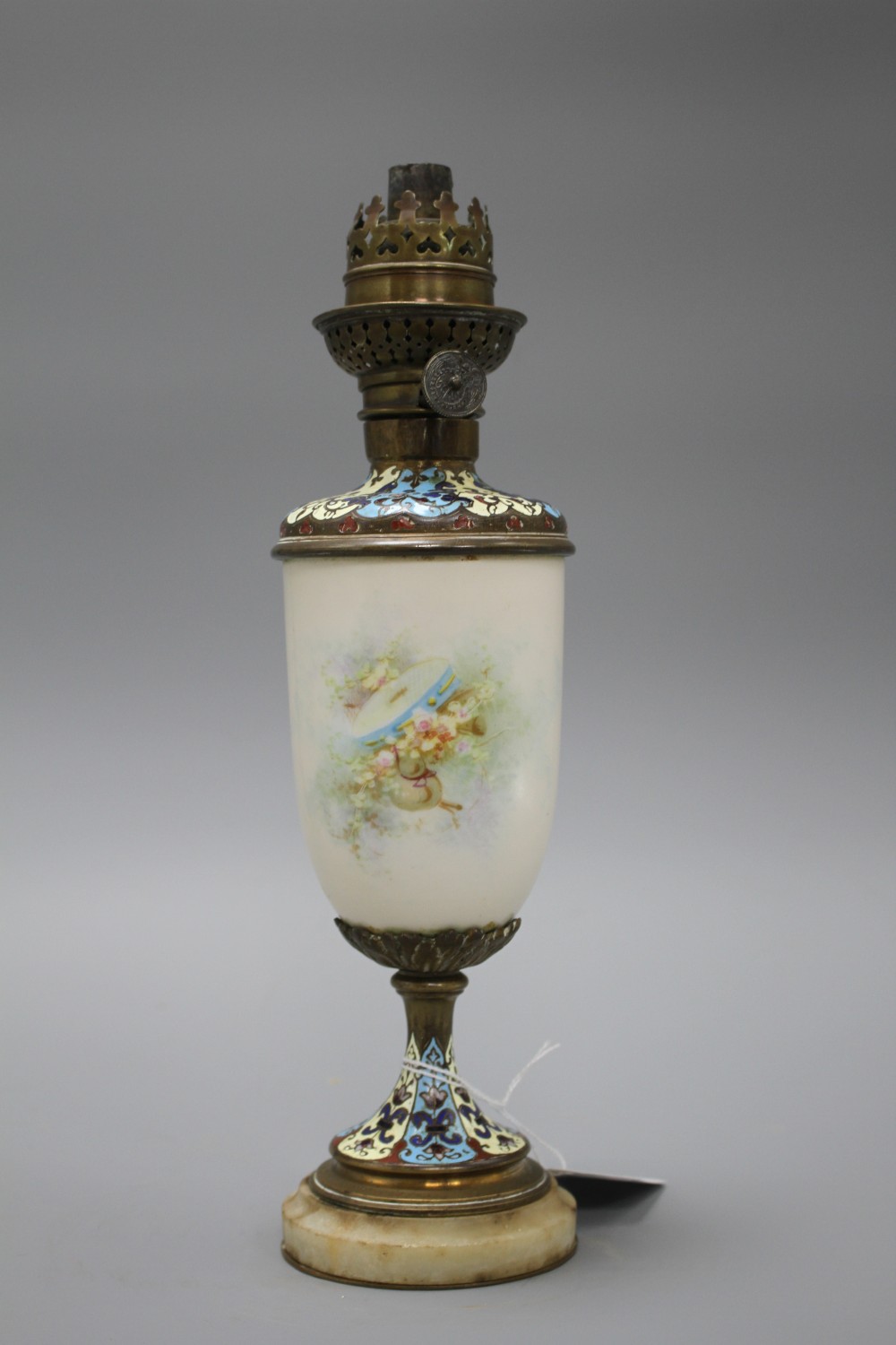 An early 20th century French champleve enamel bronze and ceramic lamp base, painted with a cherub, height 28cm